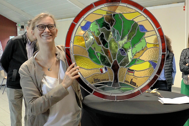 Die Glaskünstlerin Marie Payen präsentiert das Medaillon für ein Buntglasfenster mit der Partnerschaftslinde