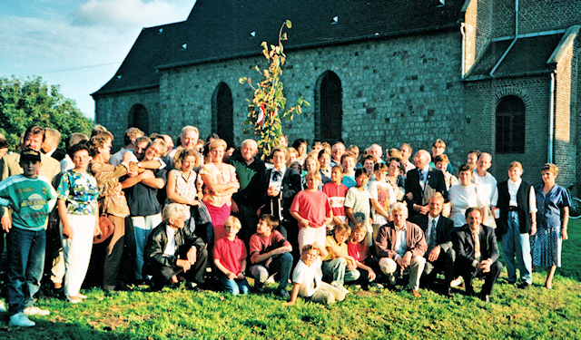 Vor dem Hintergrund der St. Landelinus-Kirche in Quérénaing umringen die Teilnehmer des Partnerschaftstreffens die soeben gepflanzte "Landelinus-Linde"